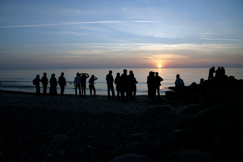 Jongeren op het strand bij zonsondergang