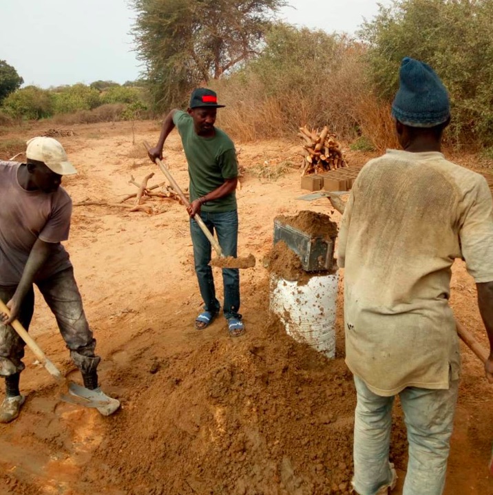 Senegalese arbeiders werken aan de bouw van een kippenkwekerij