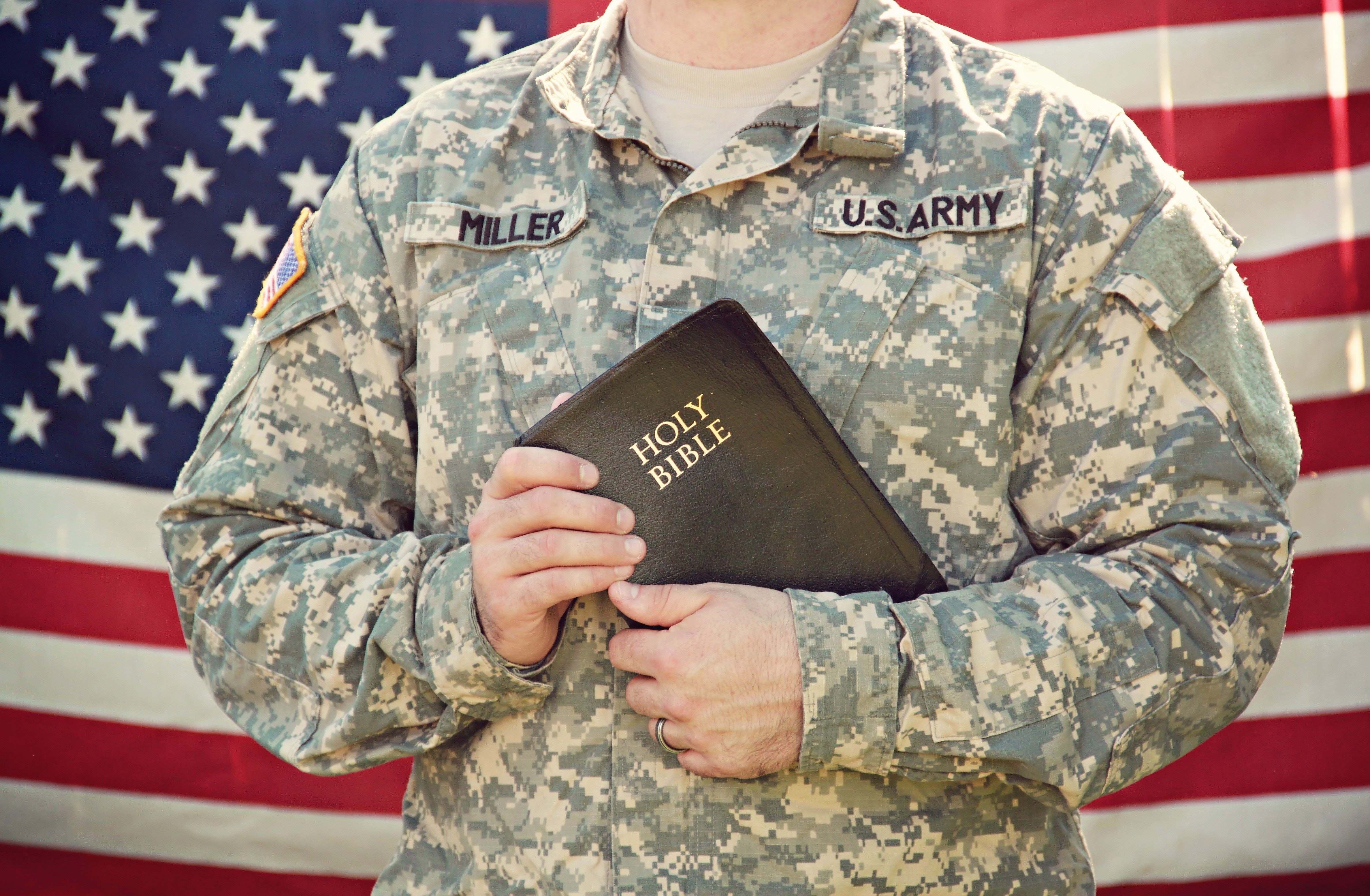 Soldaat houdt Bijbel in zijn handen.